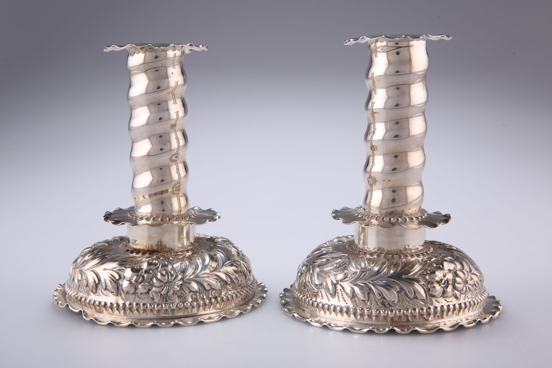 A PAIR OF VICTORIAN CHASED CANDLESTICKS, by George Fox, London 1880, each with removable drip tray