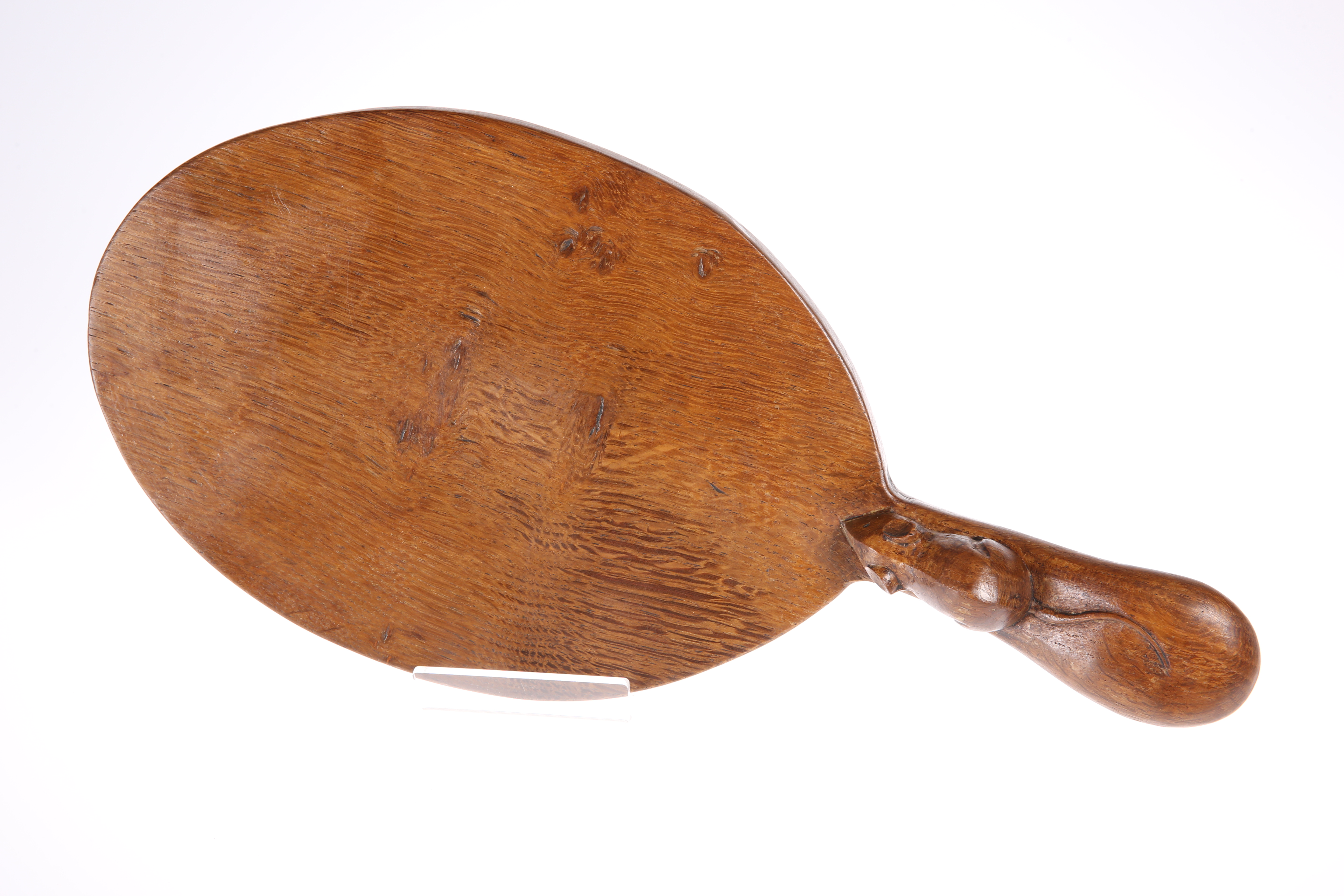 ROBERT THOMPSON OF KILBURN A MOUSEMAN OAK CHEESEBOARD, the oval board with slight adzing, carved