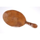 ROBERT THOMPSON OF KILBURN A MOUSEMAN OAK CHEESEBOARD, the oval board with slight adzing, carved