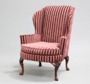 A RECENTLY RE-UPHOLSTERED AMERICAN WING-BACK ARMCHAIR, with splayed arms and bowed seat with loose