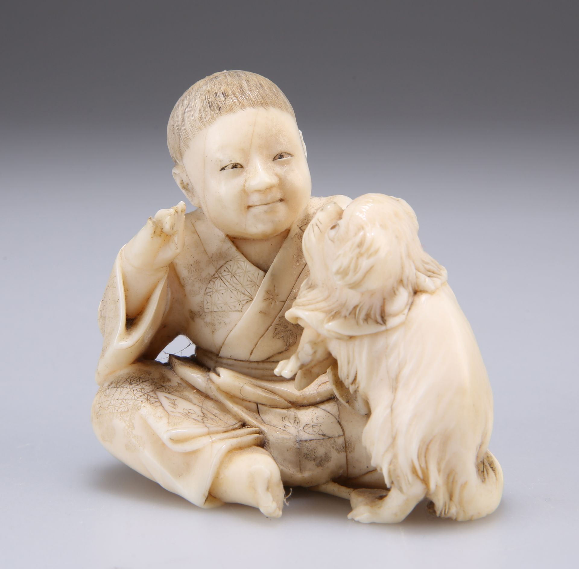 A JAPANESE IVORY NETSUKE, MEIJI PERIOD, carved as a boy playing with a dog. 6cm high - Bild 2 aus 3