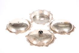 ^ A SET OF THREE EDWARDIAN SILVER MUFFIN DISHES AND COVERS, by Goldsmiths & Silversmiths Co Ltd,