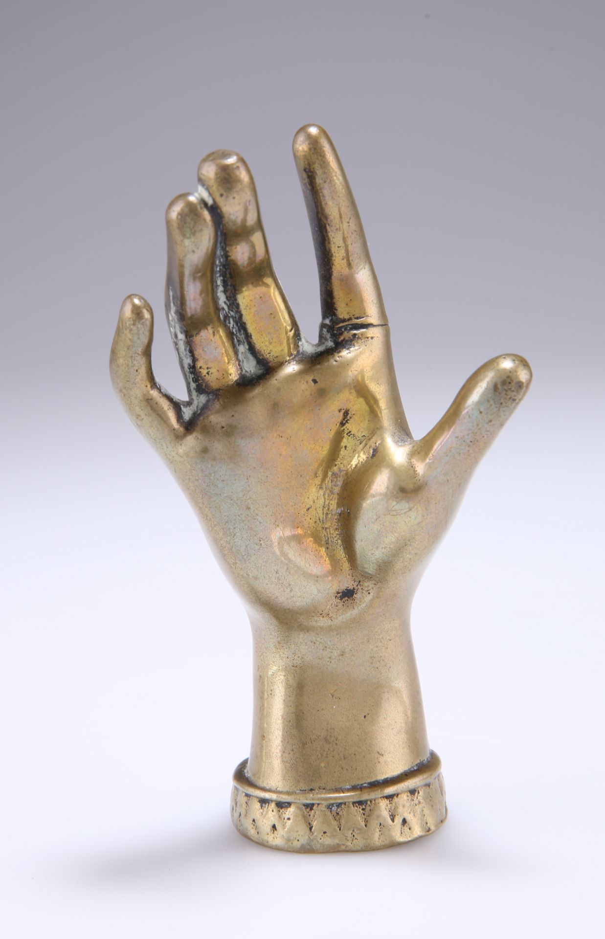 A VICTORIAN BRASS RING STAND, in the form of a hand. 12cm high