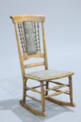 A LATE 19TH CENTURY BEECH ROCKING CHAIR, possibly American, with barley twist columns to the back.