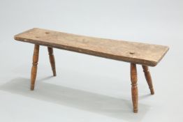 AN EARLY 19TH CENTURY ELM AND OAK BENCH, raised on splayed baluster legs. 91.5cm long