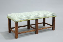 AN EARLY 19TH CENTURY OAK AND UPHOLSTERED STOOL,  raised on square section legs. 84cm long