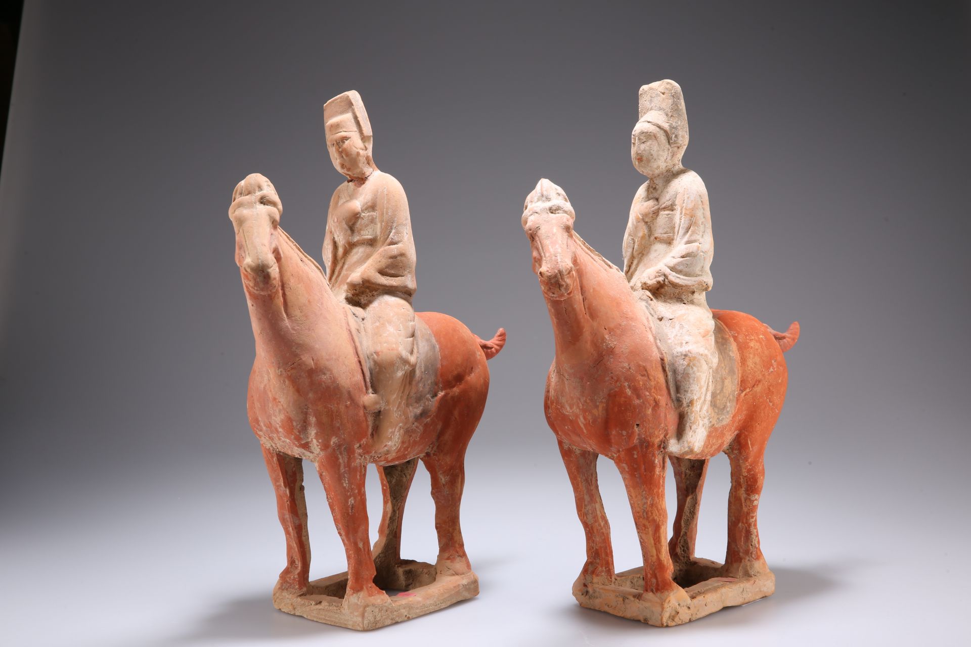 A CHINESE POTTERY HORSE AND RIDER, TANG DYNASTY (618-906AD), the figure with right arm held to his