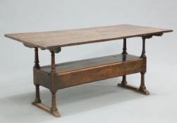 AN 18TH CENTURY OAK MONKS BENCH, the boarded framed rectangular top above a bench with scroll-carved