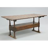 AN 18TH CENTURY OAK MONKS BENCH, the boarded framed rectangular top above a bench with scroll-carved