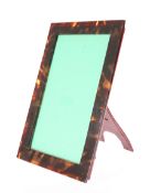 AN EARLY 20TH CENTURY TORTOISESHELL PHOTOGRAPH FRAME, rectangular, with leather easel back. 21.5cm