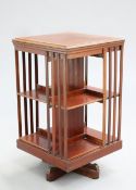 AN EDWARDIAN SATINWOOD INLAID MAHOGANY REVOLVING BOOKCASE, with moulded square top. 81cm high,