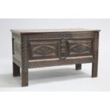 A LATE 17TH CENTURY OAK COFFER, the lid carved with scrolling foliage above a panelled case with