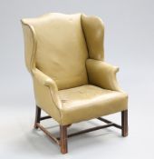 ~ A GEORGE III MAHOGANY WING-BACK ARMCHAIR, with leather upholstery, raised on moulded square-