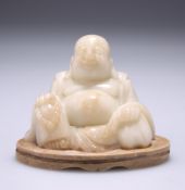 A 19TH CENTURY CHINESE SOAPSTONE FIGURE OF A BUDDHA, carved seated holding a string of beads, on