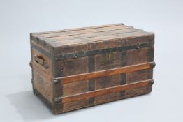 A 19TH CENTURY IRON AND OAK MOUNTED LEATHER TRUNK, rectangular, with flat hinged top and leather