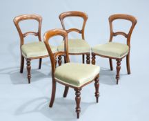 A SET OF FOUR VICTORIAN MAHOGANY DINING CHAIRS, each with waisted back and baluster legs.