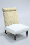 ~ A VICTORIAN EBONISED AND UPHOLSTERED COUNTRY HOUSE NURSING CHAIR, raised on turned legs moving