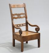 AN EARLY 19TH CENTURY ELM LAMBING CHAIR, with openwork splat and scrolling arms above a side drawer,
