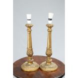 ~ A PAIR OF GILTWOOD COLUMNAR TABLE LAMPS, with fluted and leaf-collared stems. 43cm exc. fitting