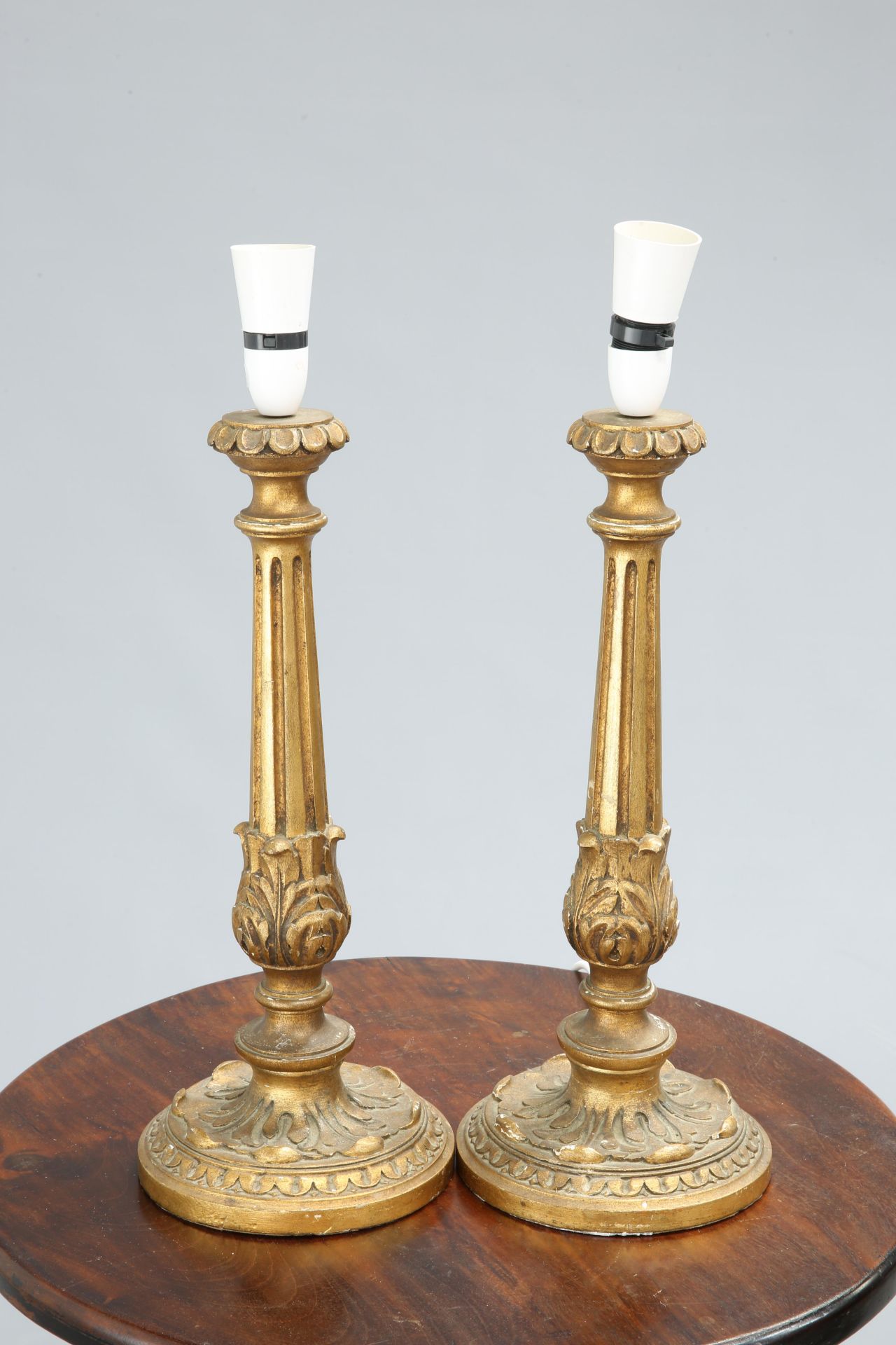 ~ A PAIR OF GILTWOOD COLUMNAR TABLE LAMPS, with fluted and leaf-collared stems. 43cm exc. fitting