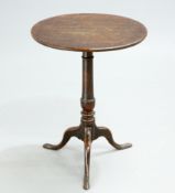 A GEORGE III OAK TILT-TOP TRIPOD TABLE, the circular top raised on a turned stem continuing to