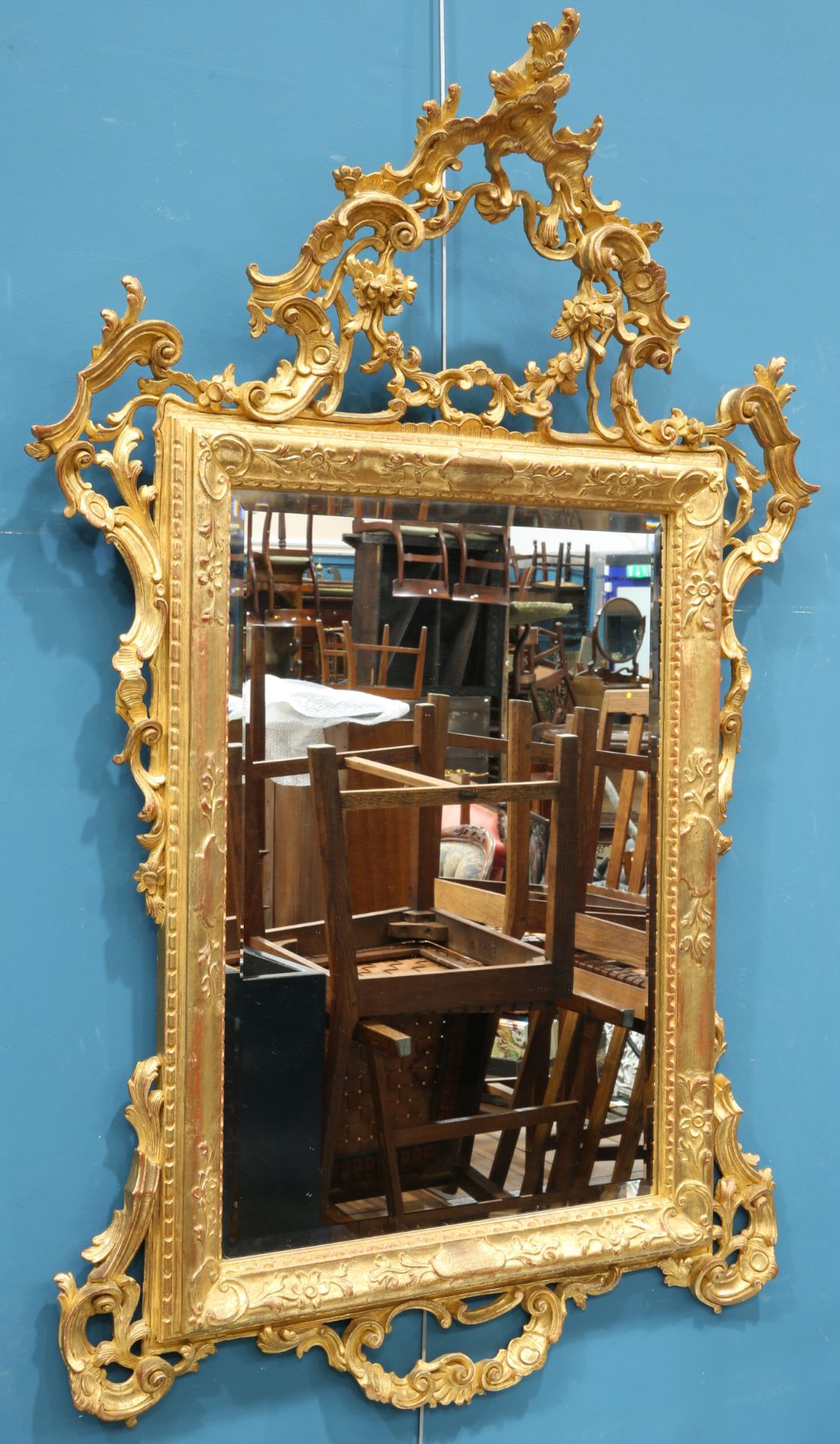 A ROCOCO STYLE GILT-COMPOSITION MIRROR, rectangular, the pierced crest moulded with C-scrolls and
