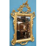 A ROCOCO STYLE GILT-COMPOSITION MIRROR, rectangular, the pierced crest moulded with C-scrolls and