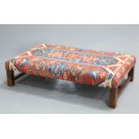 A LARGE KILIM STOOL, rectangular, raised on square-section legs joined by an H-stretcher. 152cm by