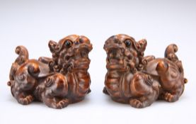 A PAIR OF CHINESE CARVED HARDWOOD FU DOGS, each with bold scroll carving and inset eyes. 5.5cm