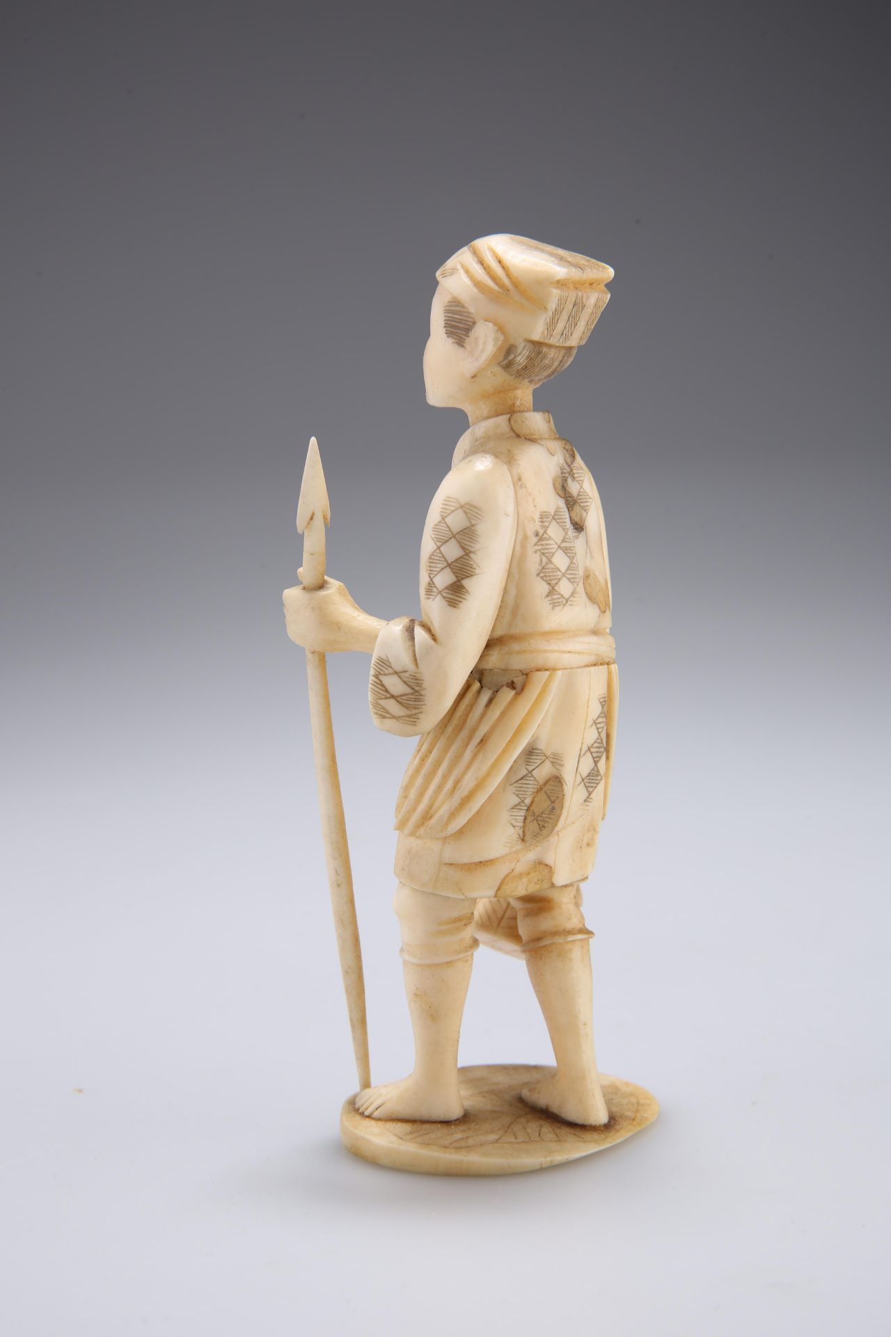 A JAPANESE IVORY OKIMONO, carved as a fisherman holding a spear and creel. 13cm high - Bild 2 aus 2