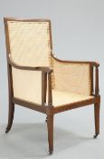 AN EDWARDIAN INLAID MAHOGANY BERGERE, IN GEORGE III STYLE, recently re-caned, the scroll-end arms