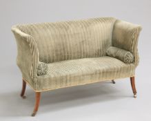 A SMALL REGENCY SETTEE, with scrolling ends, raised on splayed square-section legs, moving on