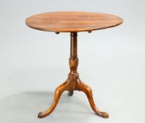 AN 18TH CENTURY YEW WOOD TILT-TOP TRIPOD TABLE, the circular top raised on a baluster stem