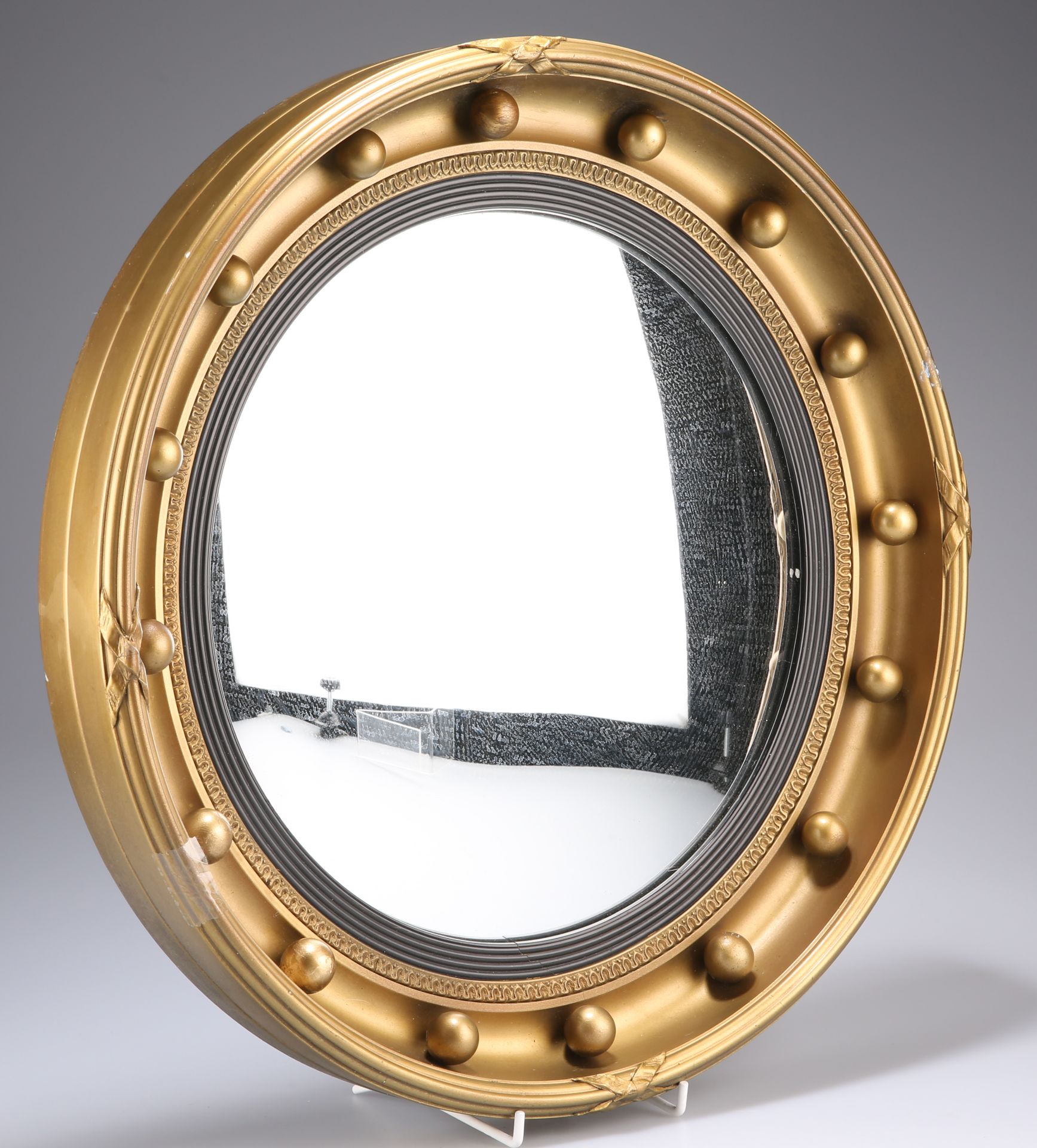 A REGENCY STYLE GILT COMPOSITION CONVEX MIRROR, the circular frame with applied balls. 41cm