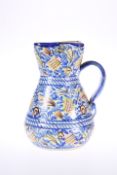 A SPANISH FAIENCE JUG, 19TH CENTURY, with strap handle. 19.5cm
