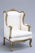 A LOUIS XV STYLE GILT AND UPHOLSTERED WINGBACK ARMCHAIR raised on cabriole legs