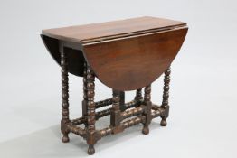 AN EARLY 18TH CENTURY OAK GATELEG TABLE, of small proportions, the twin demilune leaves supported on