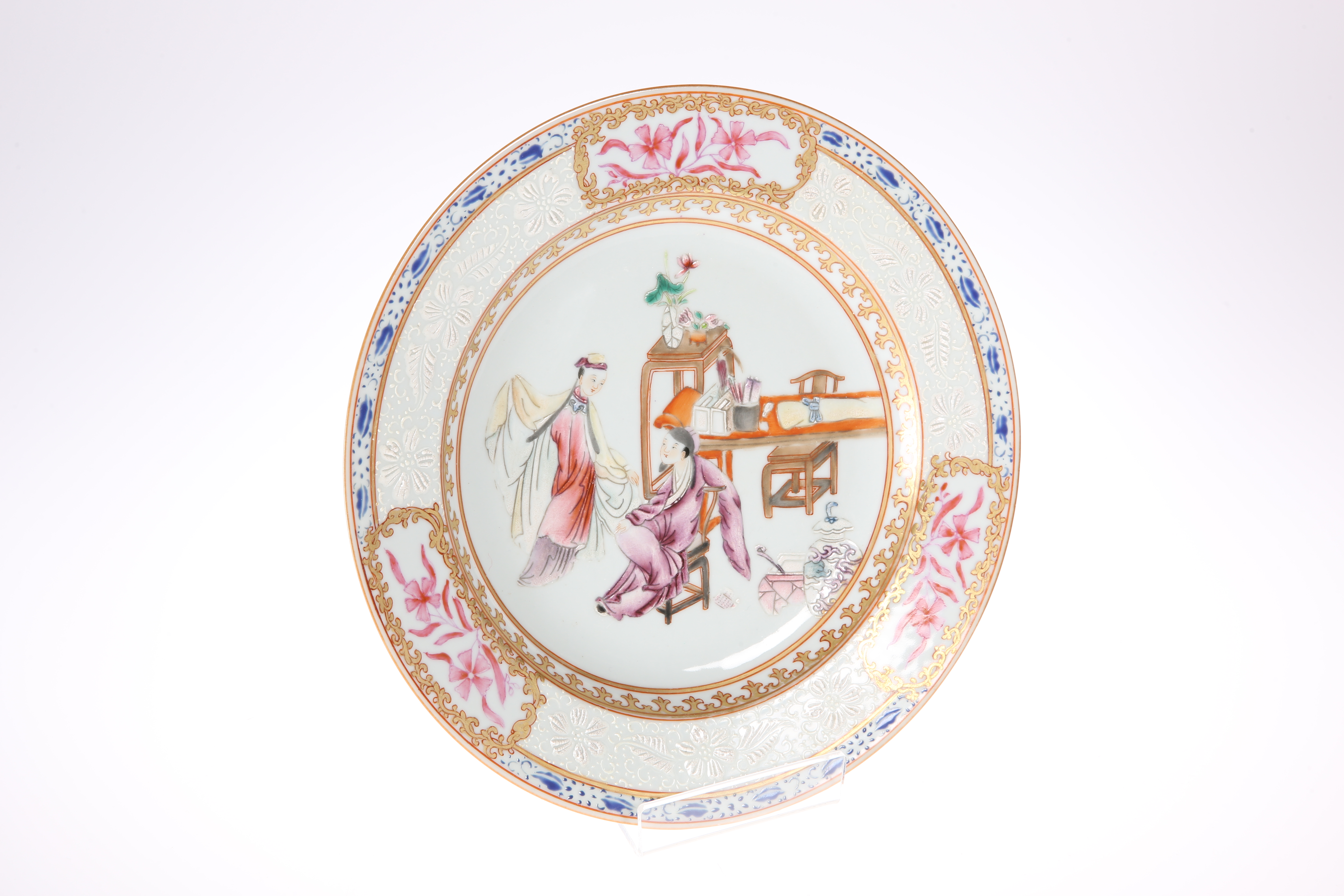 A CHINESE FAMILLE ROSE PLATE, circular, painted with two figures in an interior, within a broad