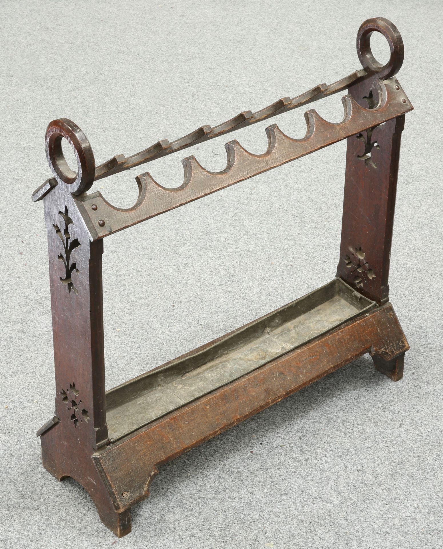 A VICTORIAN GOTHIC REVIVAL OAK STICKSTAND, with pierced trestle ends and drip tray. 72cm long