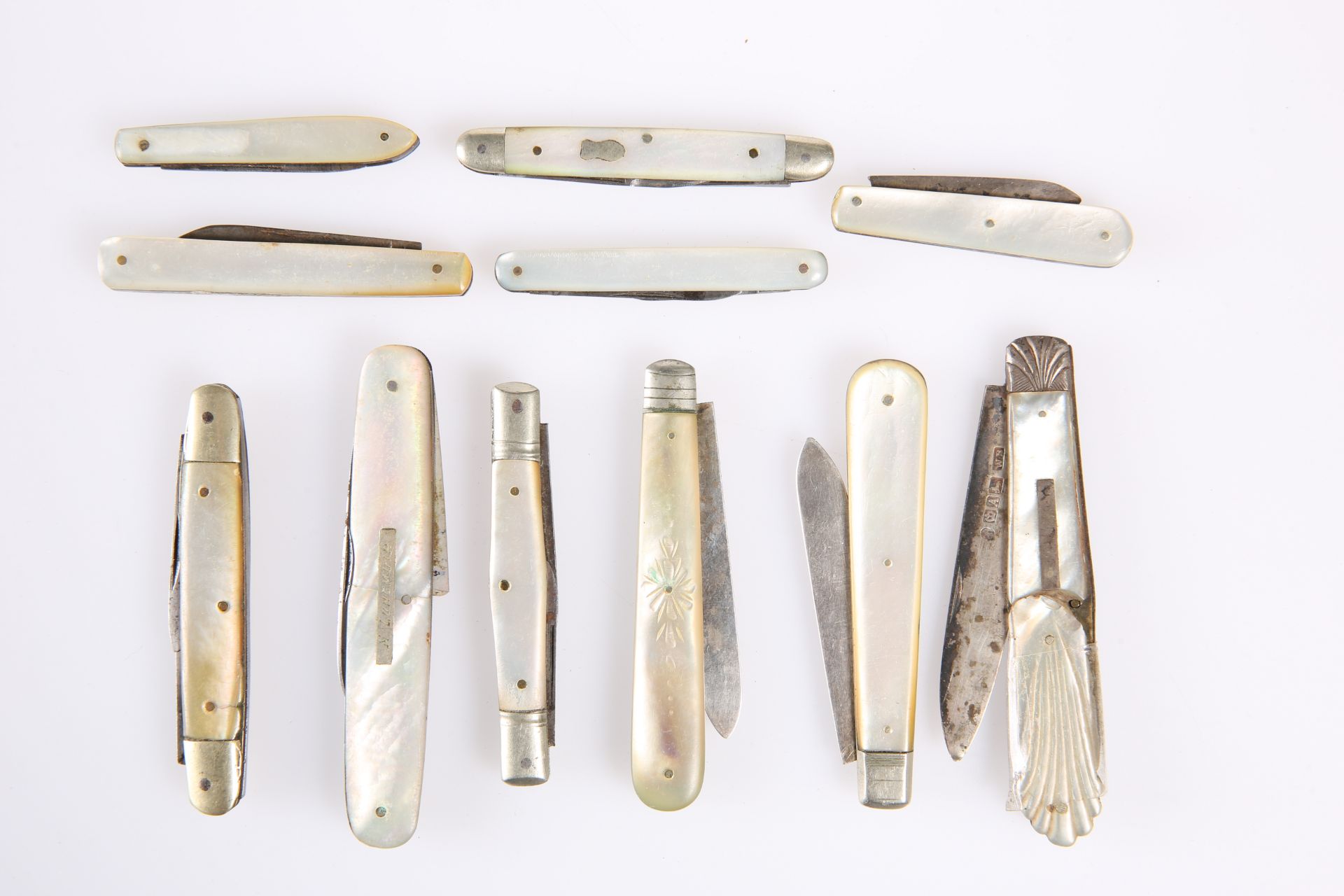 A QUANTITY OF FRUIT KNIVES WITH MOTHER-OF-PEARL FACE PLATES, some with hallmarked silver blades. (