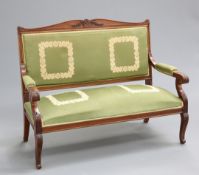 A 19TH CENTURY MAHOGANY SETTEE, in the Empire style, with scroll and foliate carved crest, the