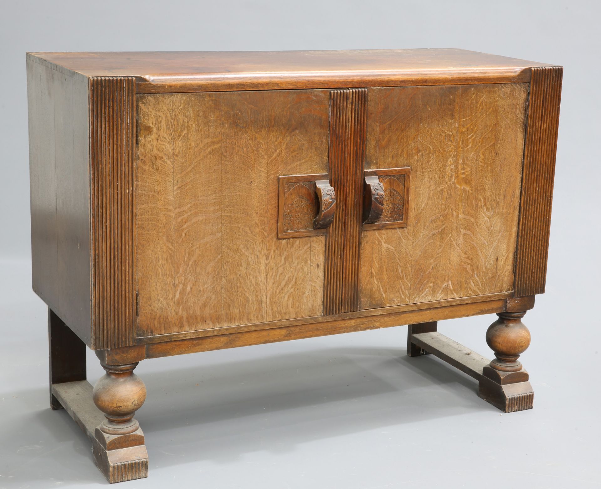 AN ART DECO OAK SIDEBOARD fitted with a pair of doors flanked by reeded pilasters. 90.5cm high,