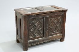 A SMALL OAK TWO-PANEL COFFER, the front panels carved with rosettes and lattice. The absence of a