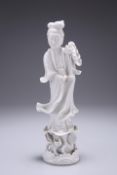 A CHINESE BLANC DE CHINE FUIGURE OF GUANYIN, modelled standing on a lotus base. 23.5cm high