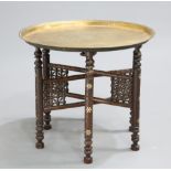 AN EARLY 20TH CENTURY BRASS-TOPPED BENARES TABLE, the circular tray top with geometric design,