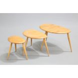 A NEST OF THREE ERCOL BLONDE ELM AND BEECH 'PEBBLE' TABLES, model 354, each labelled. Largest 65cm