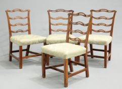 A SET OF FOUR GEORGE III MAHOGANY DINING CHAIRS, each with open wavy ladderback.