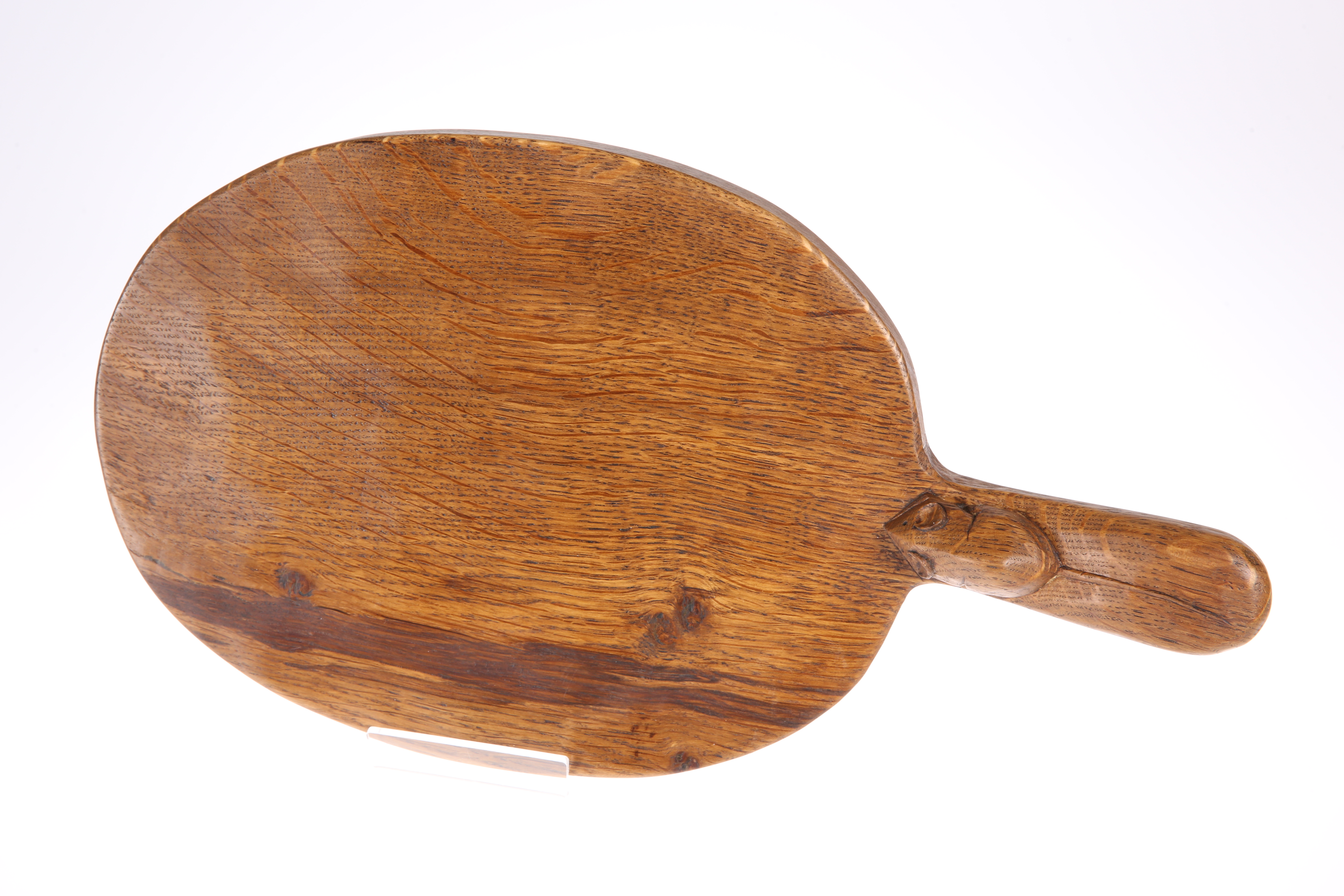 ROBERT THOMPSON OF KILBURN A MOUSEMAN OAK CHEESEBOARD, the adzed oval board with darker grains,