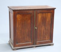 ~ A REGENCY MAHOGANY SIDE CABINET, the rectangular top with beaded edge over a pair of further