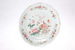 AN 18TH CENTURY CHINESE FAMILLE ROSE DISH, shaped circular form, enamel painted with a vase of